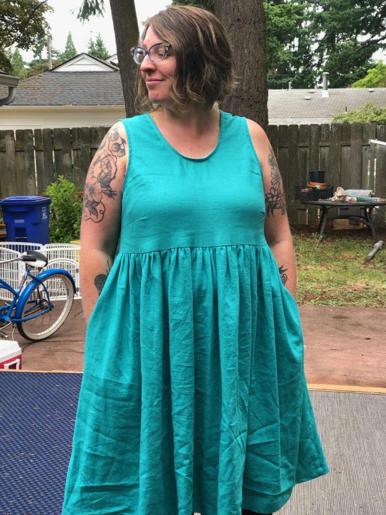 I am kind of looking off to the side, with my hands in the pockets of another new dress.